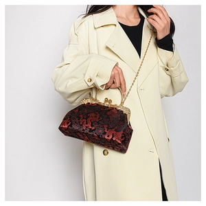 Detail of vintage Chinese dragon embroidery on a silk shell bag with metal handles