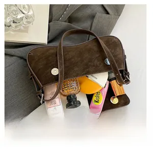 Top-down view of a brown suede shoulder bag showing internal capacity and daily essentials