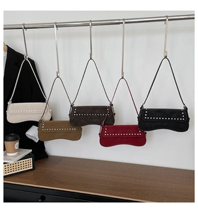 Row of five colorful retro suede shoulder bags featuring decorative silver studs