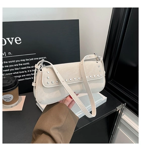 Close-up of cream white rivet underarm bag with silver studs and adjustable strap