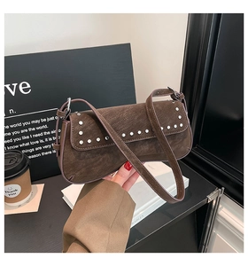 Detail view of dark brown vintage baguette bag with silver studs and retro leather texture