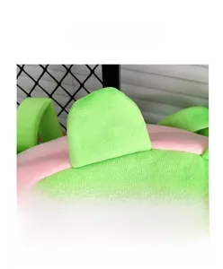 Gros plan détaillé du sac dinosaure en peluche vert et rose avec un tissu texturé doux