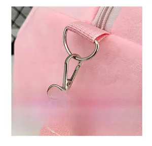 Détail macro du crochet métallique argenté et de la sangle en peluche rose du sac