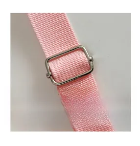 Détail de la bandoulière tissée rose avec boucle de réglage en métal argenté