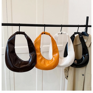 Détail de quatre sacs hobo en cuir verni brillant en marron, orange, blanc et noir