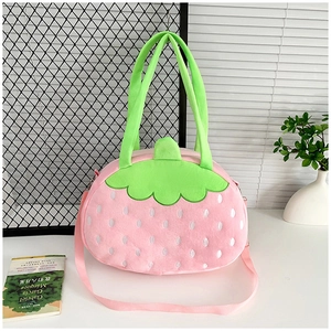 Détail du sac seau fraise en peluche avec décor de feuilles vertes et texture rose douce