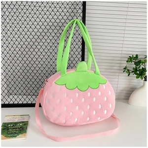 Détail du sac fraise en peluche rose avec pois blancs et accents de feuilles vertes