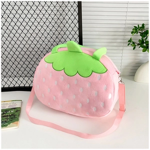 Détail du sac fraise en peluche rose avec feuilles vertes et motif à pois blancs et bandoulière