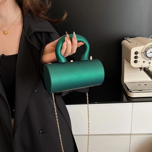 Deep green acrylic cylinder clutch bag with golden chain strap and top handle