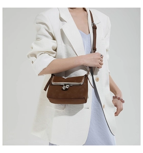 Detail of dark brown suede crossbody bag with vintage silver metal kiss-lock closure