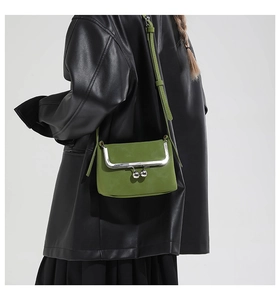 Détail d'un sac vintage vert avocat avec fermoir en métal argenté et bandoulière en cuir