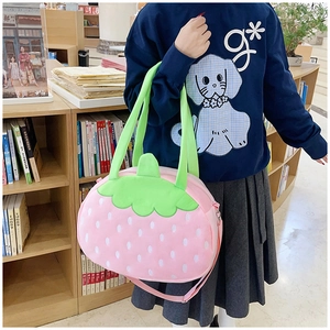 Vue détaillée du sac peluche fraise rose avec pois blancs et feuilles vertes