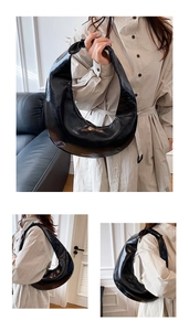Détail du sac croissant noir brillant avec texte doré et fermeture à glissière