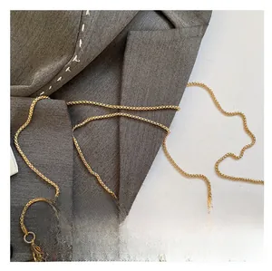 Detail of elegant gold woven chain strap and metallic handle on evening shell bag