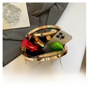 Interior view of gold metal shell clutch bag showing storage for phone and cosmetics