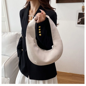 Détail du sac bandoulière demi-lune crème avec texture en cuir lisse et fermeture