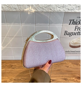 Detail of pink glitter evening clutch bag featuring a gold hollow metal handle and shimmer finish