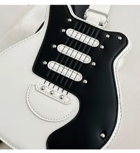 Close-up of guitar-shaped crossbody bag featuring metal rivets and black-white PU leather