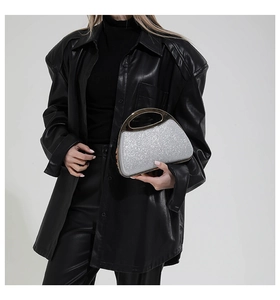 Detail of silver sequin evening bag with metal handle and smooth shell structure