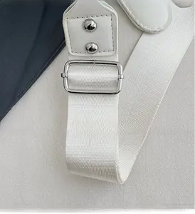 Detail of adjustable white nylon strap with silver metal buckle and rivets on guitar bag