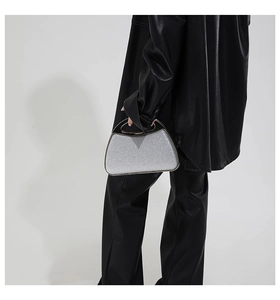 Silver glitter evening shell bag with metal handle styled on black leather outfit