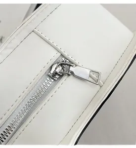Close-up of smooth silver metal zipper and hardware on white leather guitar bag