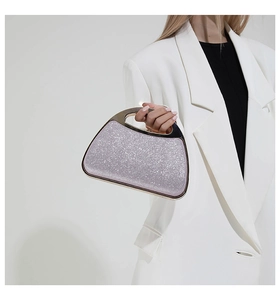 Detail of glittery purple sequins and golden metal handle on an elegant evening clutch bag