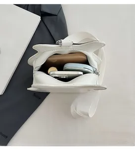 Interior view of white crossbody bag showing spacious storage for makeup and smartphone