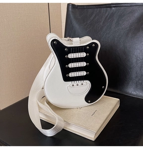 Detail of guitar shaped shoulder bag with metal rivets and b&w faux leather texture