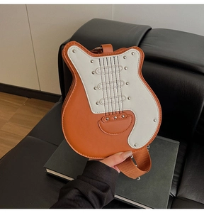 Detail of orange guitar shaped crossbody bag with metallic rivets and stylish strap