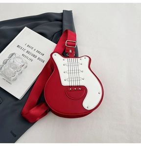 Detail of red and white electric guitar shaped crossbody bag with metallic rivets and strap