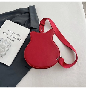 Detailed top view of red guitar-shaped leather crossbody bag with wide woven strap