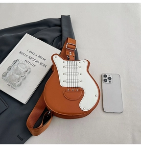Detailed close-up of a guitar-shaped orange PU leather crossbody bag with silver rivets