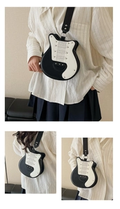 Detail of guitar-shaped crossbody bag with rivet accents and adjustable black shoulder strap