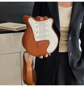 Detail of guitar-shaped crossbody bag featuring metal rivets and leather stitching