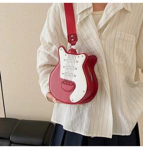 Close-up of guitar-shaped crossbody bag with rivet details and colorful stitching worn by model
