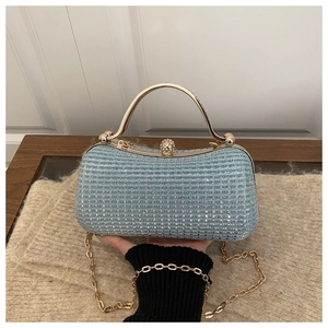 Detail of light blue sequin evening bag with gold metal handle and rhinestone clasp