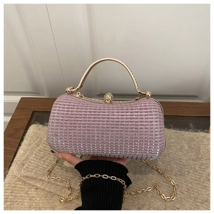 Close-up of pink sequin evening clutch with golden metal handle and rhinestone clasp
