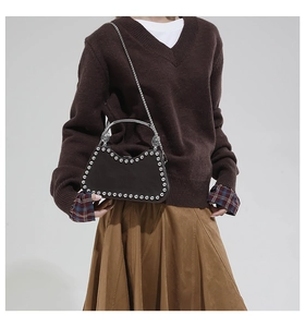 Détail d'un petit sac bandoulière tendance avec rivets argentés et poignée métal