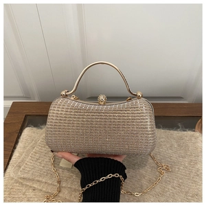 Close-up of gold sequin evening clutch bag with pearl clasp and metal handle detail