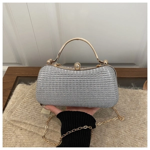 Detail of silver sequin evening bag with gold metal handle and crystal clasp