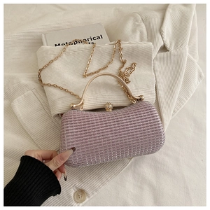 Close-up of pink sequined evening clutch with crystal ball clasp and gold chain strap