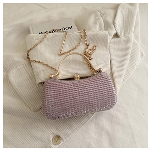 Detail of lavender textured box bag with gold metal handle and rhinestone clasp