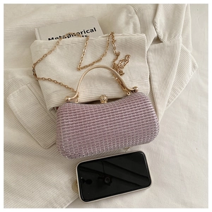 Pink evening clutch featuring golden handle, rhinestone clasp, and a chain strap detail