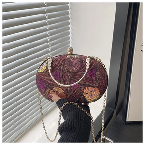 Detalle de bordado floral con lentejuelas moradas en un bolso de lujo con cadena de oro