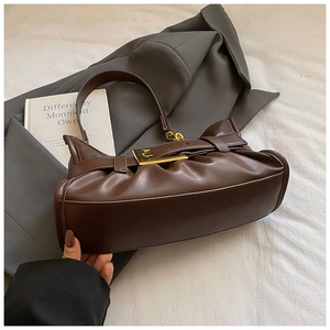 Detalle del bolso nube marrón oscuro con hebilla dorada y textura de cuero mate fino