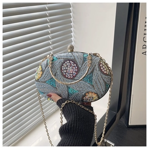 Detalle del bolso de fiesta con lentejuelas y bordado floral en 3D dorado