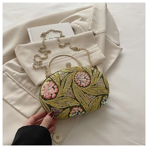 Detalle de bordado de lentejuelas verdes y asa dorada en el bolso de noche retro