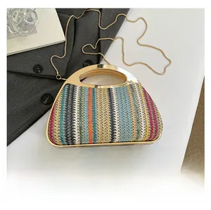 Detail der bunten Strohtasche mit goldenem Metallgriff und Kettenriemen für Damen