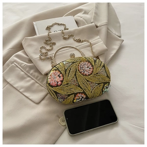 Detalle del bolso de noche verde oscuro con bordado de hojas y lentejuelas